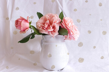Spring, summer still life scene. Vintage wedding feminine styled photo, floral composition. Bouquet of pink roses in a white vase.
