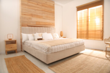 Blurred view of stylish hotel room interior with comfortable bed