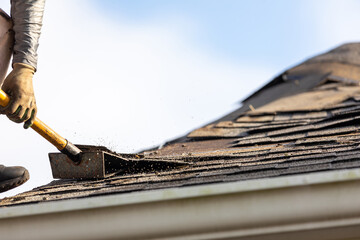 roofer removing roof nails with roof shingle remover