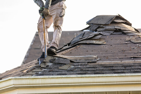 roofer removing roof nails with roof shingle remover