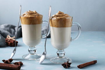 Dalgona creamy coffee in two glasses on blue background with whipped foam. Korean coffee trend