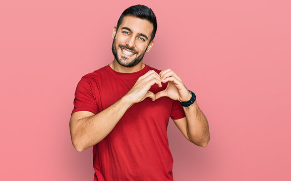 Young hispanic man wearing casual clothes smiling in love showing heart symbol and shape with hands. romantic concept.