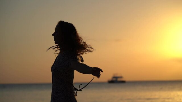 happy woman dance during sunset at the seascape. Concept of healthy lifestyle and present moment 