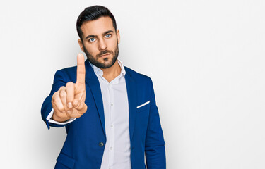 Young hispanic man wearing business jacket pointing with finger up and angry expression, showing no...