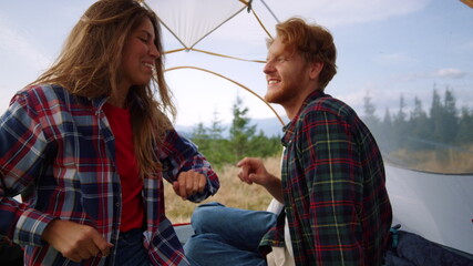 Woman and man flirting with each other in camp tent. Couple embracing together
