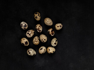 Geometric shapes from quail eggs on a black textured background. Scattering