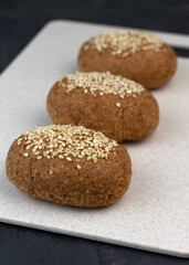 A healthy gluten-free keto bread made from almond flour and psyllium husk, sprinkled with sesame seeds. Baking ingredients in scoops. Ketogenic diet, paleo, low carb, high fat.