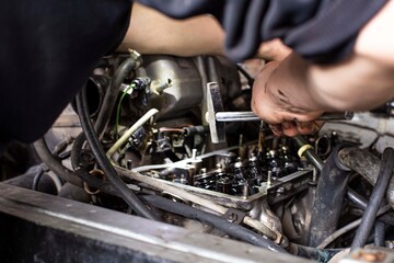 a mechanic performing diagnostics and repairs of a car, the front and background background is blurred with bokeh effect