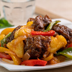 Sweet and sour sauced deep fried pork ribs with chopped pepper and pineapple.