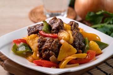 Sweet and sour sauced deep fried pork ribs with chopped pepper and pineapple.