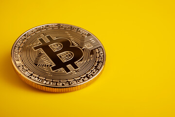 Golden bitcoin on a yellow background