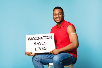 African Man Holding Board Advertising Covid-19 Vaccination Over Blue Background