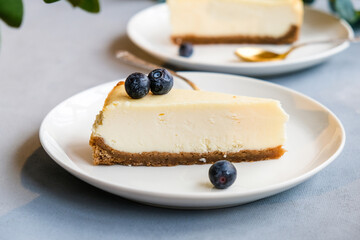 Plates with sliced classic New York cheesecake decorated fresh blueberries. Sweet delicious cake dessert.