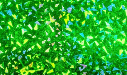 Green foil with holographic effect. Holiday background. Holographic foil reflection. Confetti in air pattern.