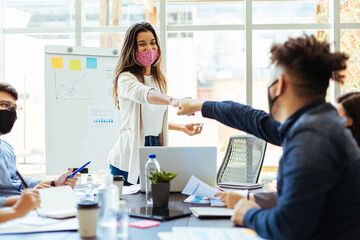 Business team wearing protective masks while meeting in the office during the COVID-19 epidemic