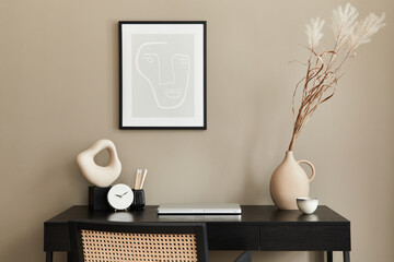 Stylish composition of home office interior with black wooden desk, chair, dried flower in vase, laptop, mock up poster frame, cup of coffee, clock and elegant office accessories. Template.