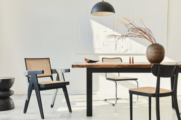 Minimalist composition of dining room interior with wooden table, design chairs, dried flowers in a...