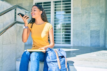 Young african american student girl sending audio message using smartphone at university.