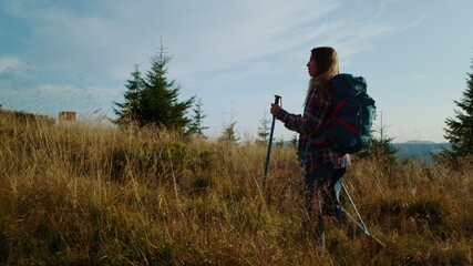 Focused girl hiking on mountain road. Female hiker trekking in mountains