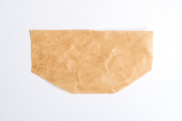 Close up of a ripped piece of brown paper on white background