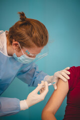 scientist in a protective suit injecting a syringe with a substance against the exact type of...