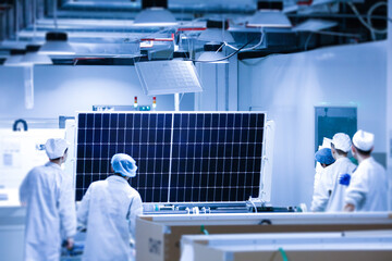 Factory workers lifting new solar panel from production line,and  the technician is checking it in the factory.Intelligent industrial background image.