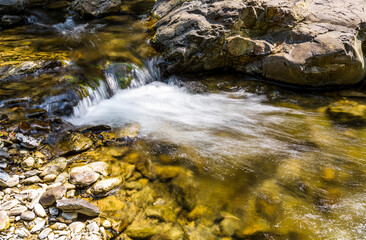 Creek or stream water flowing past rocks and stones