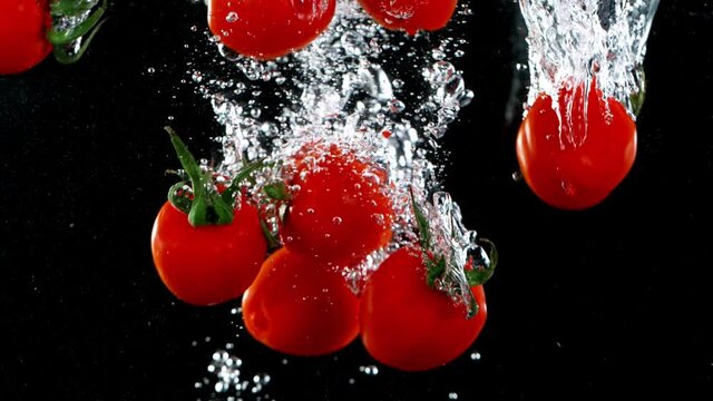 Super slow motion of falling cherry tomatoes
