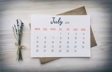 Calendar page: July 2021. Paper calendar on white paper for the whole month, on top of kraft paper...