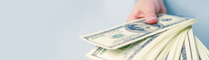 Hand giving money. Loan, mortgage, business, profit and money concept. Selective focus on US Dollar bill.