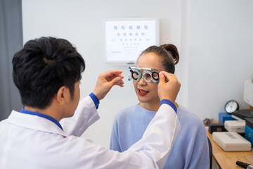 Obraz premium Selective focus at women face. While doctor using Optometry equipment and trial glasses frame to examine eye visual system of elder patient women with professional machine and technic.