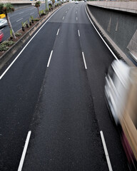 A delivery truck in movement on a black asplalt road, light trails and intentional movement/zoom...