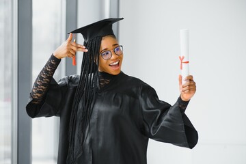 happy african american female student with diploma at graduation