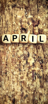 APRIL text on wooden cubes in vintage background. Stock photo.