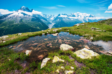 Fantastic view with stones in the water on the background of Mont Blanc in the French Alps, Europe on a sunny morning.