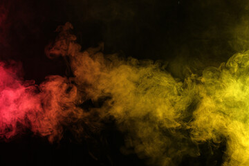 Smoke in red-yellow light on black background in darkness