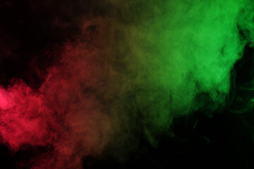 Smoke in red-green light on black background in darkness
