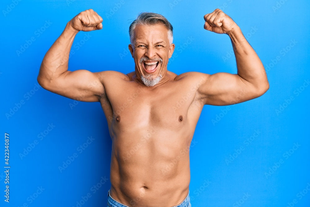 Poster middle age grey-haired man standing shirtless doing fitness gesture smiling and laughing hard out lo