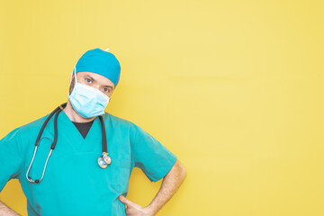 doctor dressed as a surgeon in green with stethoscope and mask on a yellow background with a worried expression.