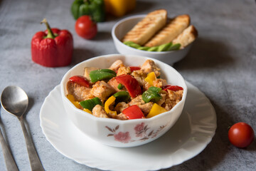 Close up of  minced chicken pieces and bell peppers in a bowl with use of selective focus.