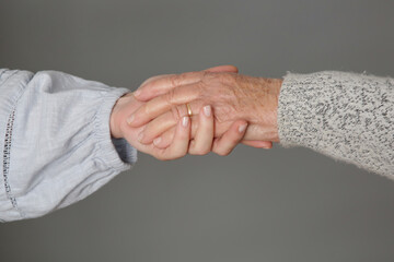 Holding hands. A picture of young and old hands. Concept of hope, care, love and support.	