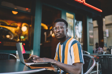 Fototapeta premium Thoughtful freelancer using laptop in cafe