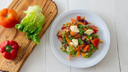 flat lay of a fresh tasty salad on top of a white table	