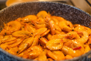 Appetizing and juicy shrimps lie in a frying pan in the kitchen