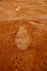 Human footprints in red volcanic soil.