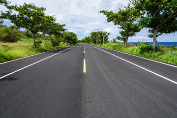 Fototapeta na wymiar Asphalt road with blue sky in the countryside of Pingtung, Taiwan.