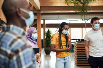 Diverse businesspeople in masks talking at work