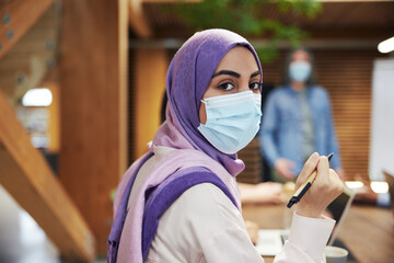 Muslim businesswoman wearing a face mask in a meeting - Powered by Adobe