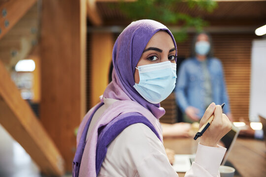 Muslim businesswoman wearing a face mask in a meeting