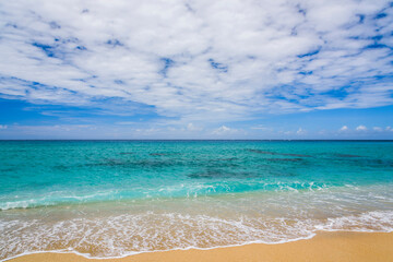 Ocean waves, beach, and blue sky in the Kenting National Park of Pingtung, Taiwan.